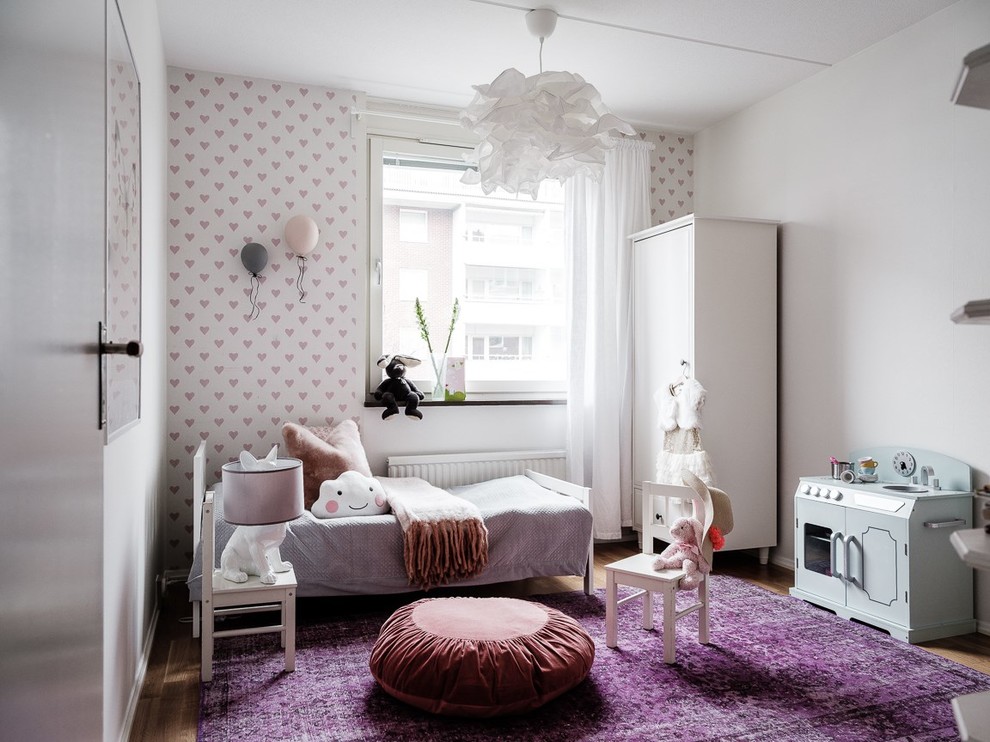 Photo of a scandinavian kids' bedroom in Stockholm with white walls, medium hardwood floors and brown floor.