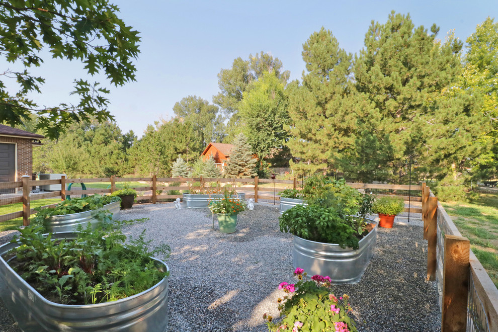 Large front yard full sun formal garden in Denver with a vegetable garden and gravel for summer.