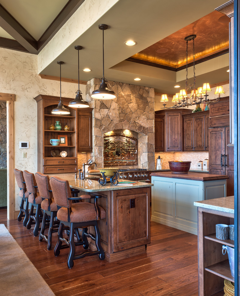 Mountain style u-shaped eat-in kitchen photo with a farmhouse sink, raised-panel cabinets, dark wood cabinets, wood countertops, white backsplash, stone tile backsplash and stainless steel appliances