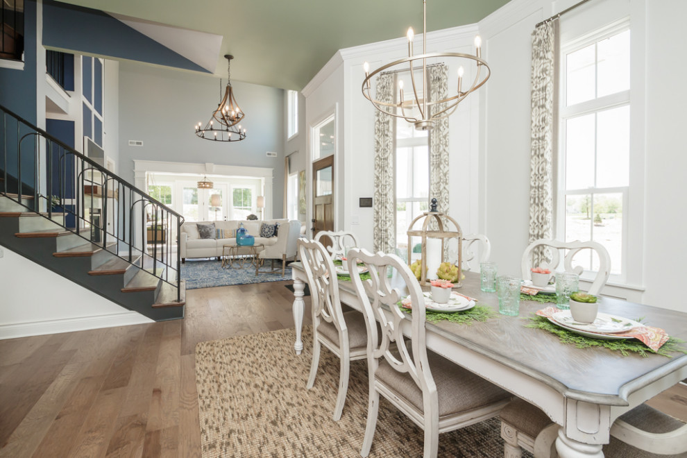 This is an example of a large transitional open plan dining in Atlanta with white walls, medium hardwood floors, no fireplace, brown floor and vaulted.