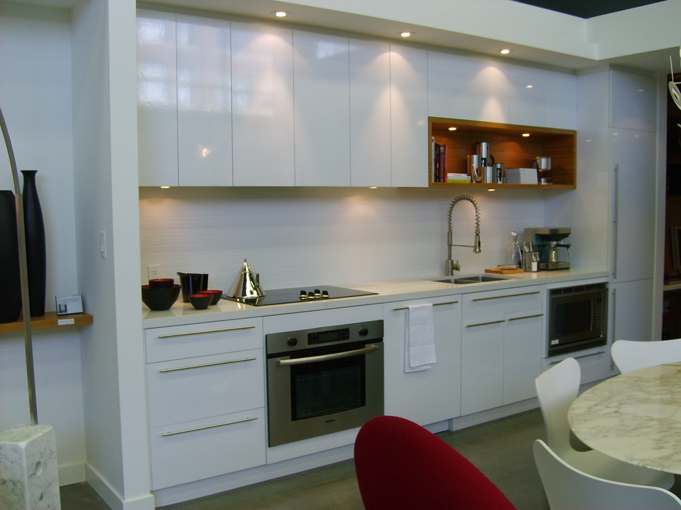 Contemporary single-wall eat-in kitchen in Vancouver with an undermount sink, flat-panel cabinets, white cabinets, quartz benchtops, white splashback, ceramic splashback and stainless steel appliances.
