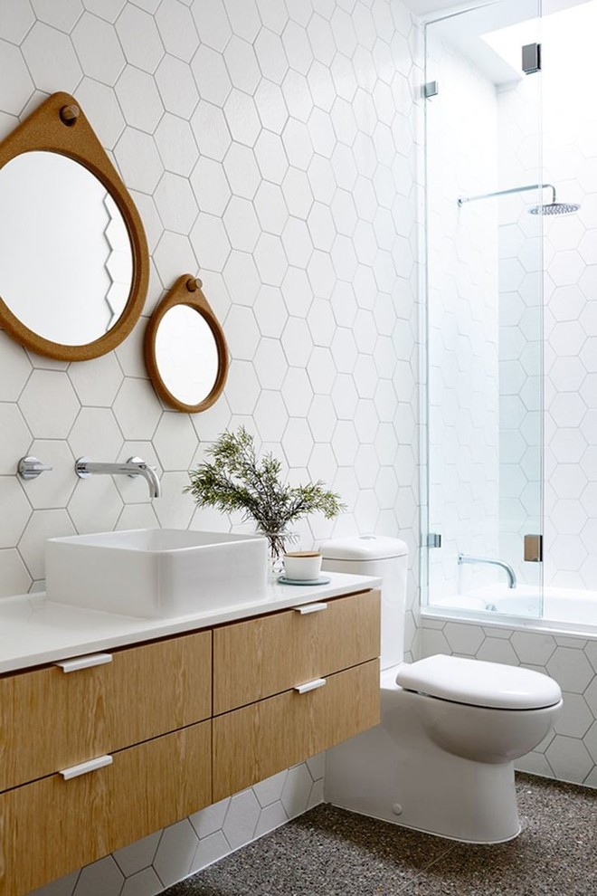 This is an example of a contemporary bathroom in Melbourne with an alcove tub, white tile, a vessel sink, flat-panel cabinets, medium wood cabinets, a shower/bathtub combo and a two-piece toilet.