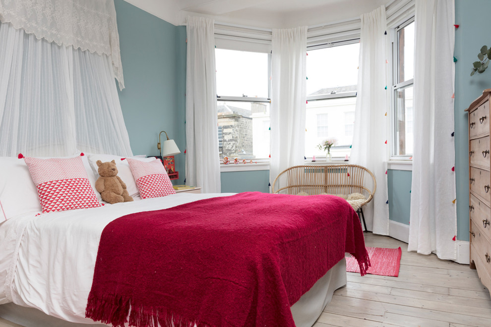 This is an example of a mid-sized transitional kids' bedroom for girls in Edinburgh with blue walls, light hardwood floors and beige floor.