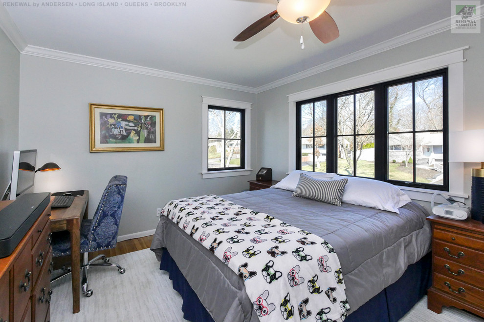 Modelo de dormitorio de tamaño medio sin chimenea con paredes grises, suelo de madera en tonos medios y suelo multicolor