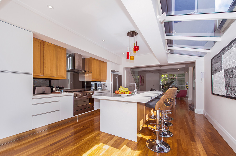 Design ideas for a modern kitchen in Sydney with white cabinets, stainless steel appliances and with island.