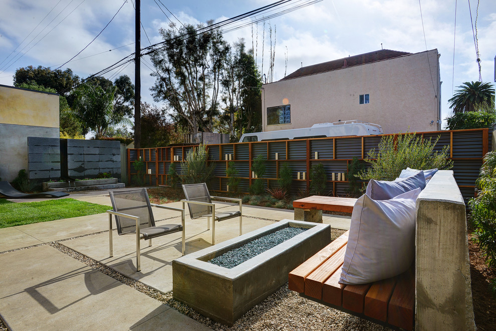 This is an example of a contemporary backyard patio in Los Angeles with a fire feature, concrete pavers and no cover.