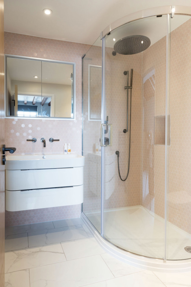 Small modern master bathroom in London with flat-panel cabinets, white cabinets, a corner shower, a wall-mount toilet, pink tile, ceramic tile, white walls, ceramic floors, a drop-in sink, grey floor, a sliding shower screen, a niche, a single vanity and a floating vanity.