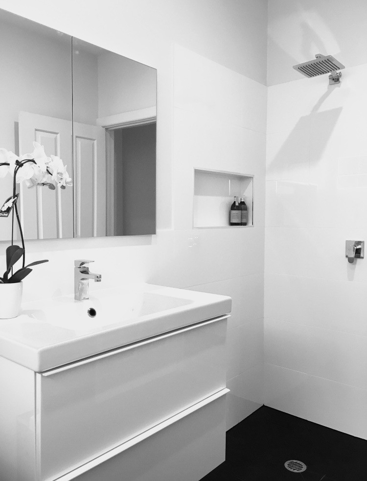 This is an example of a mid-sized contemporary kids bathroom in Melbourne with flat-panel cabinets, white cabinets, a drop-in tub, a curbless shower, white tile, ceramic tile, white walls, ceramic floors, an undermount sink and engineered quartz benchtops.