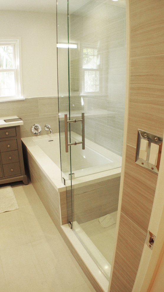 This is an example of a mid-sized contemporary master bathroom in Los Angeles with furniture-like cabinets, grey cabinets, a corner tub, a corner shower, a two-piece toilet, porcelain tile, grey walls, travertine floors, an undermount sink and engineered quartz benchtops.