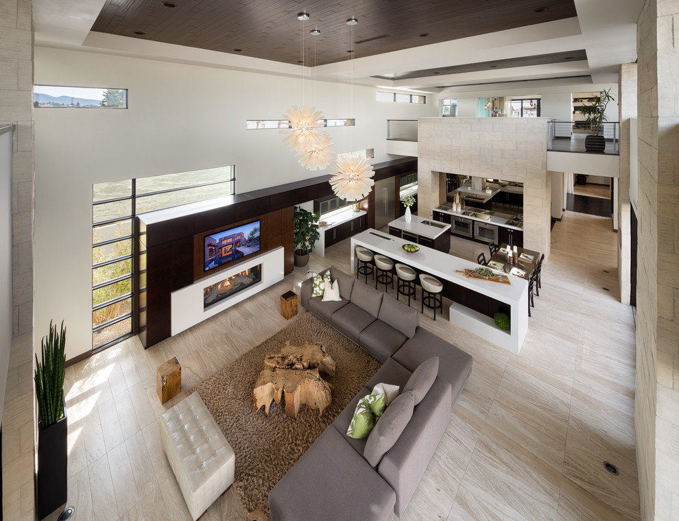 This is an example of an expansive contemporary open concept living room in Las Vegas with a ribbon fireplace and a built-in media wall.