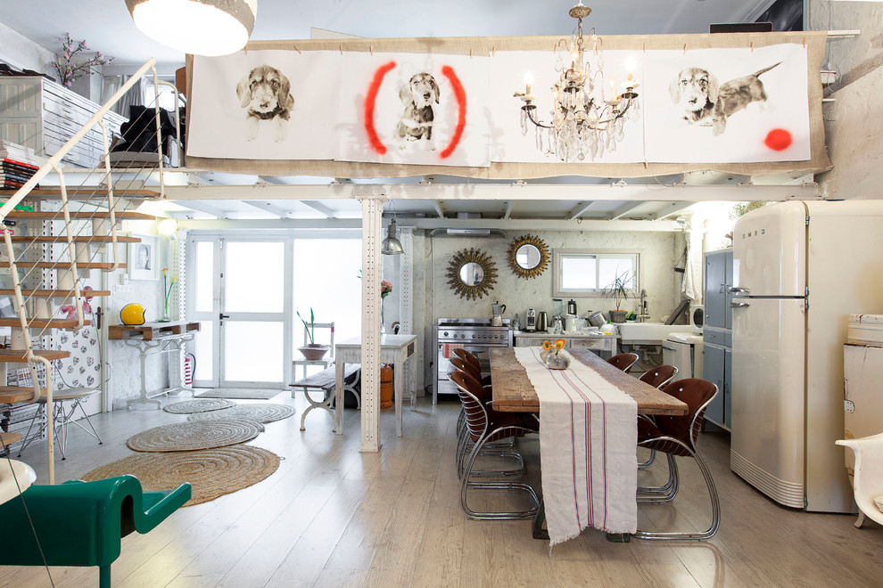 Photo of an expansive eclectic open plan dining in Madrid with white walls, light hardwood floors and no fireplace.
