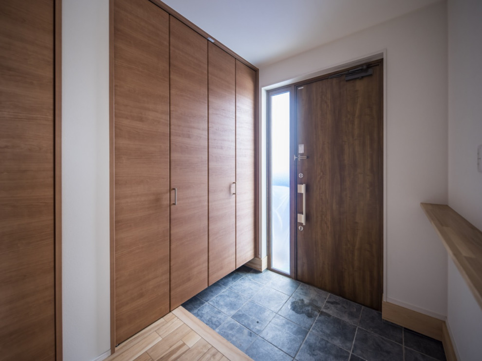 Modelo de puerta principal blanca moderna de tamaño medio con paredes blancas, suelo de madera clara, puerta simple, puerta marrón, suelo marrón, papel pintado y papel pintado