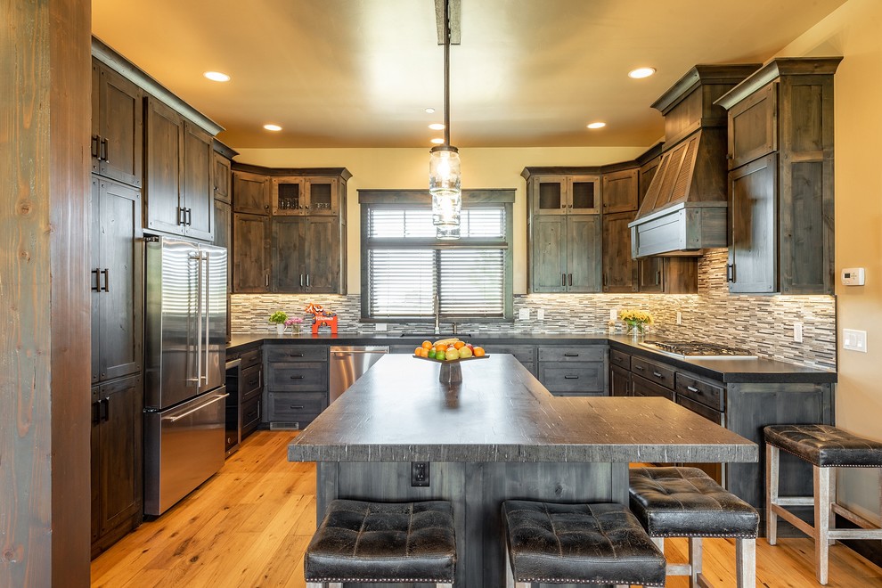 Photo of a country u-shaped kitchen in Salt Lake City with shaker cabinets, dark wood cabinets, multi-coloured splashback, matchstick tile splashback, stainless steel appliances, medium hardwood floors, with island, brown benchtop and granite benchtops.