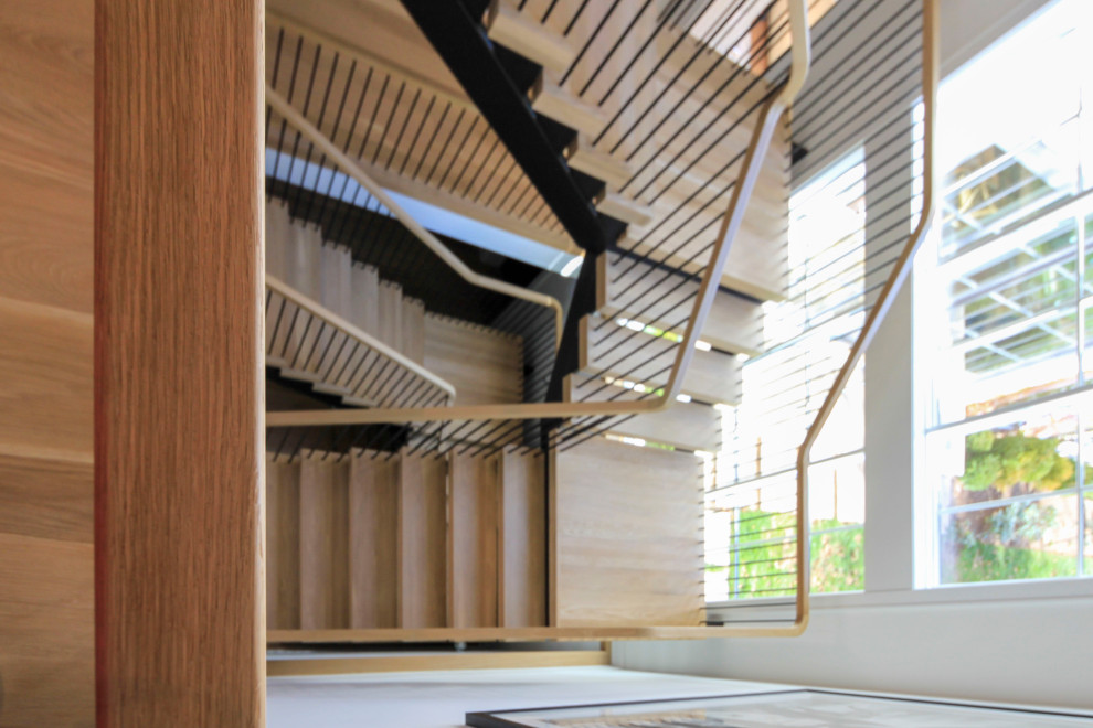 На фото: огромная лестница на больцах в стиле модернизм с деревянными ступенями, перилами из смешанных материалов и стенами из вагонки
