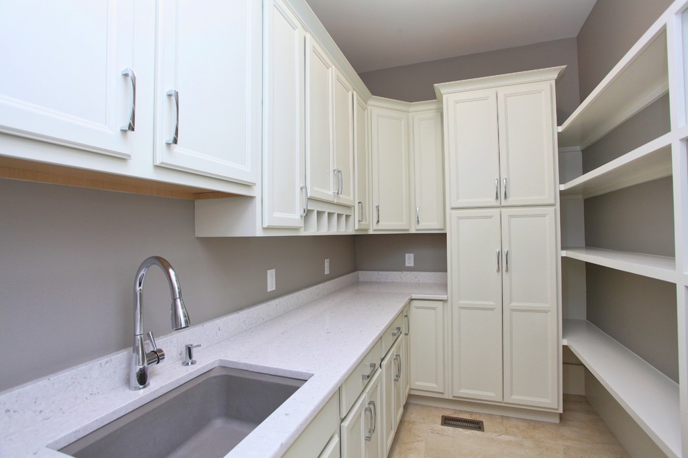 Example of a huge transitional l-shaped marble floor and beige floor enclosed kitchen design in Raleigh with an undermount sink, raised-panel cabinets, stainless steel appliances, an island, white cabinets, quartz countertops and white countertops