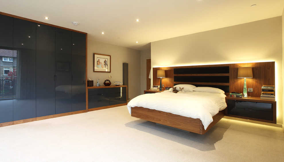 This is an example of a large modern master bedroom in Manchester with grey walls, carpet and grey floor.