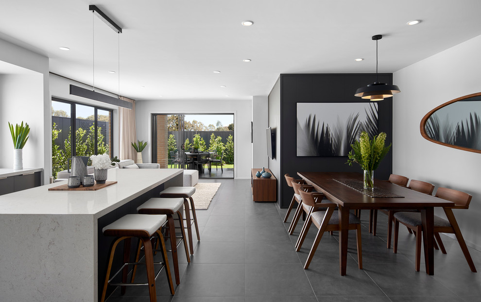 Contemporary open plan dining in Melbourne with white walls and grey floor.