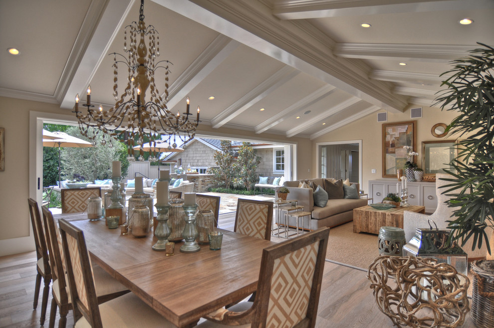 This is an example of a beach style dining room in Los Angeles with beige walls and light hardwood floors.