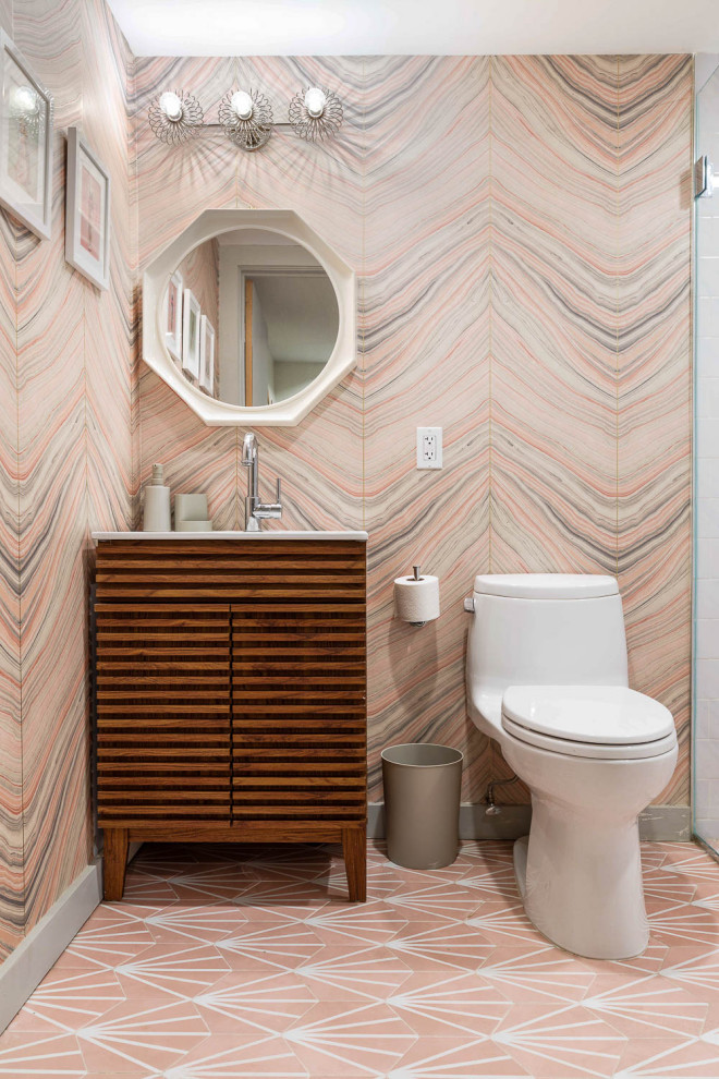 Medium sized traditional ensuite bathroom in New York with raised-panel cabinets, medium wood cabinets, a one-piece toilet, marble tiles, pink walls, cork flooring, white floors, a single sink and a freestanding vanity unit.