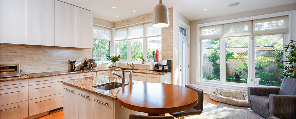 Example of a mid-sized transitional l-shaped medium tone wood floor and brown floor eat-in kitchen design in Ottawa with a single-bowl sink, flat-panel cabinets, beige cabinets, granite countertops, beige backsplash, stone tile backsplash, stainless steel appliances and an island