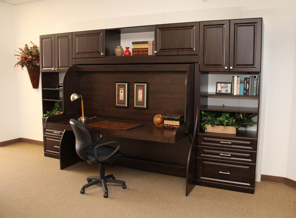 This is an example of a mid-sized traditional home office in Jacksonville with beige walls, carpet, no fireplace, a built-in desk and brown floor.