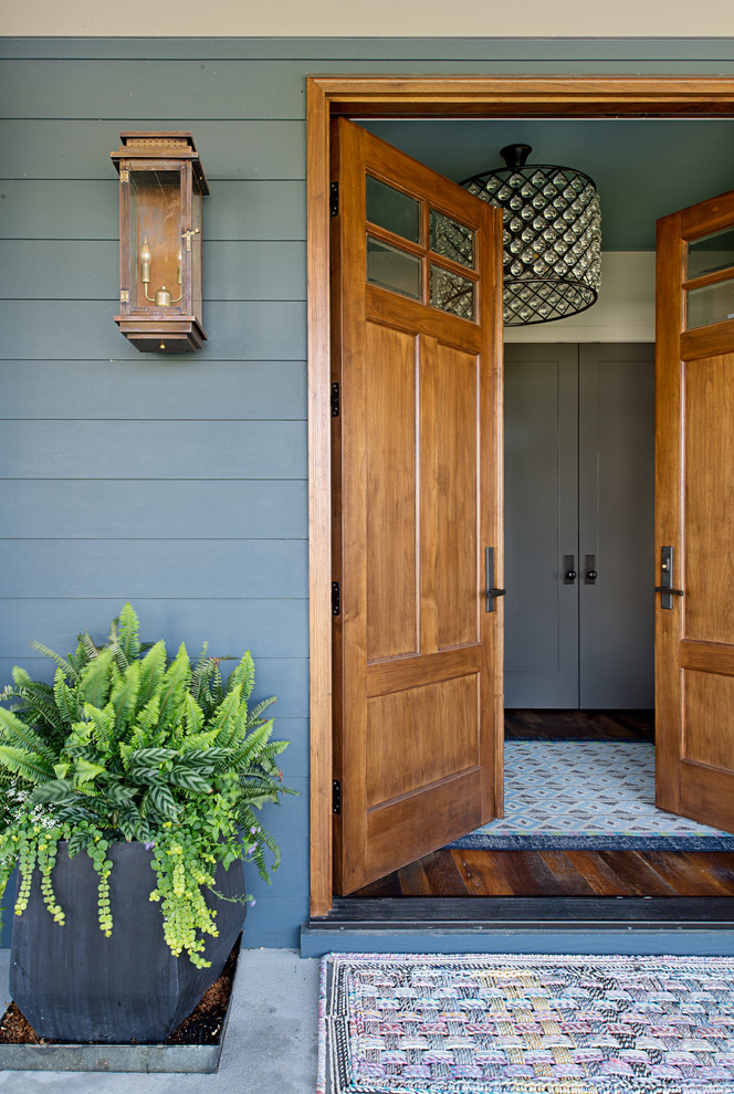 Photo of a mid-sized transitional front door in Other with a double front door, a medium wood front door and blue walls.