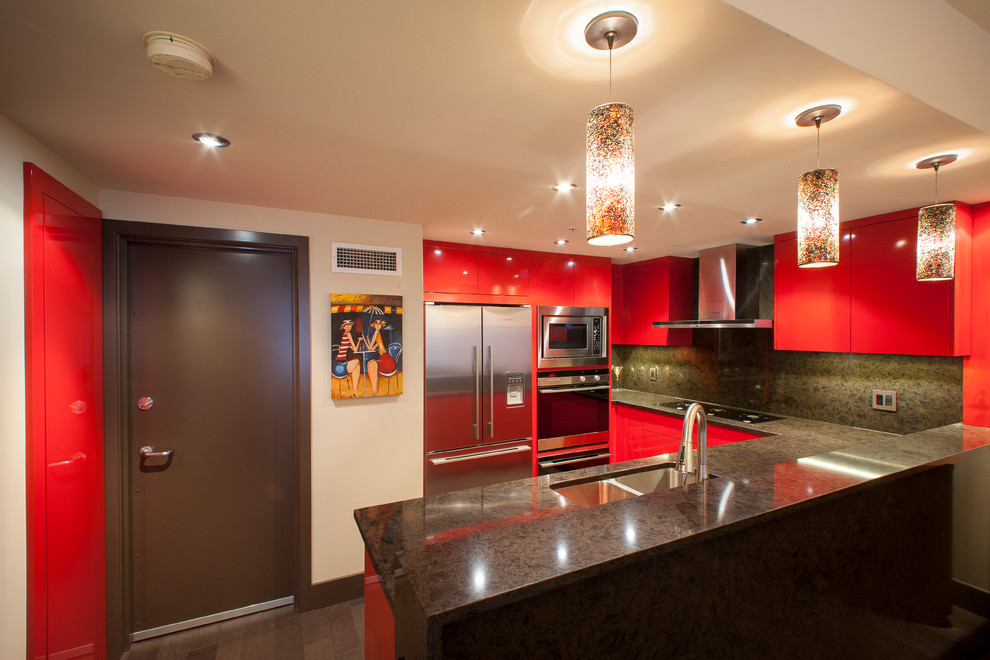 Inspiration for a mid-sized eclectic l-shaped eat-in kitchen in Vancouver with a double-bowl sink, flat-panel cabinets, red cabinets, quartz benchtops, black splashback, stainless steel appliances, dark hardwood floors and a peninsula.