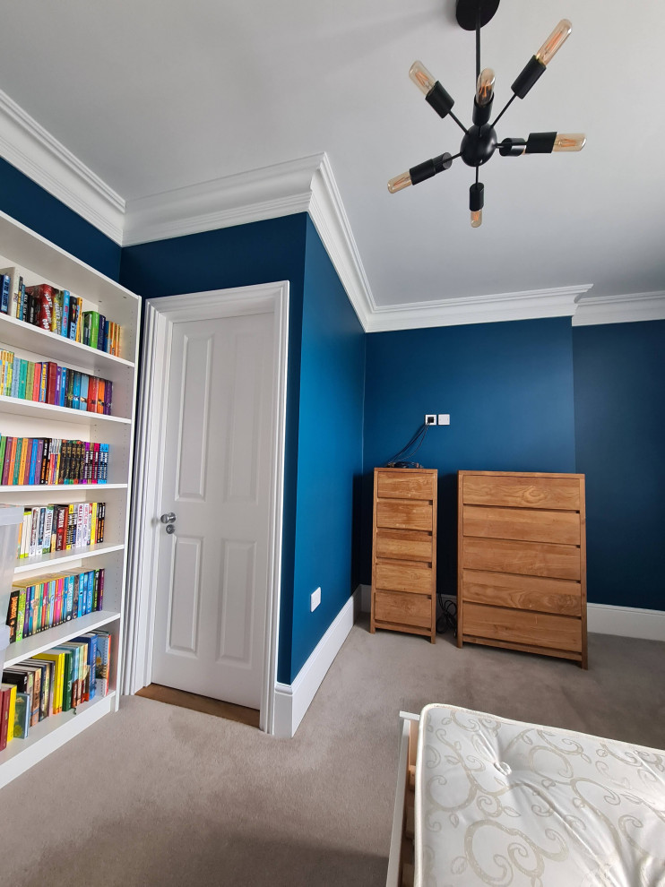This is an example of a large traditional master bedroom in London with blue walls, carpet, beige floors and a drop ceiling.