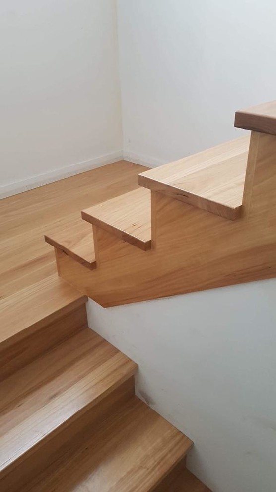 Contemporary wood l-shaped staircase in Sydney with wood risers and wood railing.