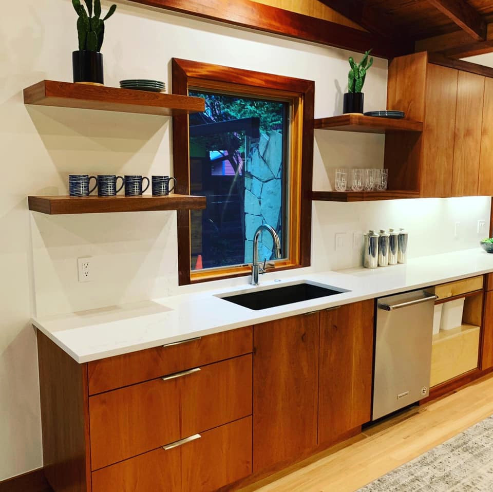 Mid-sized country l-shaped eat-in kitchen in Austin with an undermount sink, flat-panel cabinets, medium wood cabinets, quartz benchtops, white splashback, ceramic splashback, stainless steel appliances, light hardwood floors, yellow floor and white benchtop.