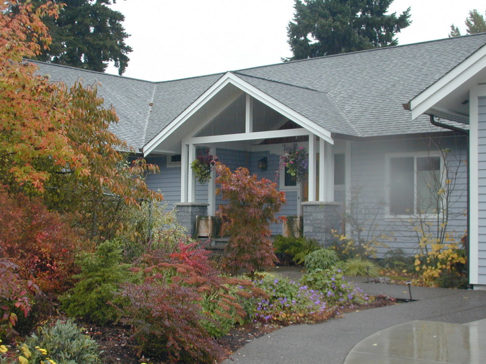 Photo of a mid-sized traditional front yard driveway for fall in Portland with a garden path and concrete pavers.