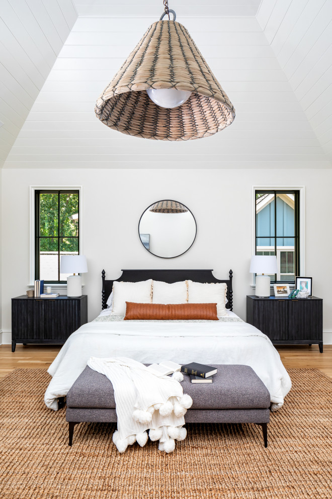 Inspiration for a traditional master bedroom in Charlotte with white walls, light hardwood flooring and a vaulted ceiling.