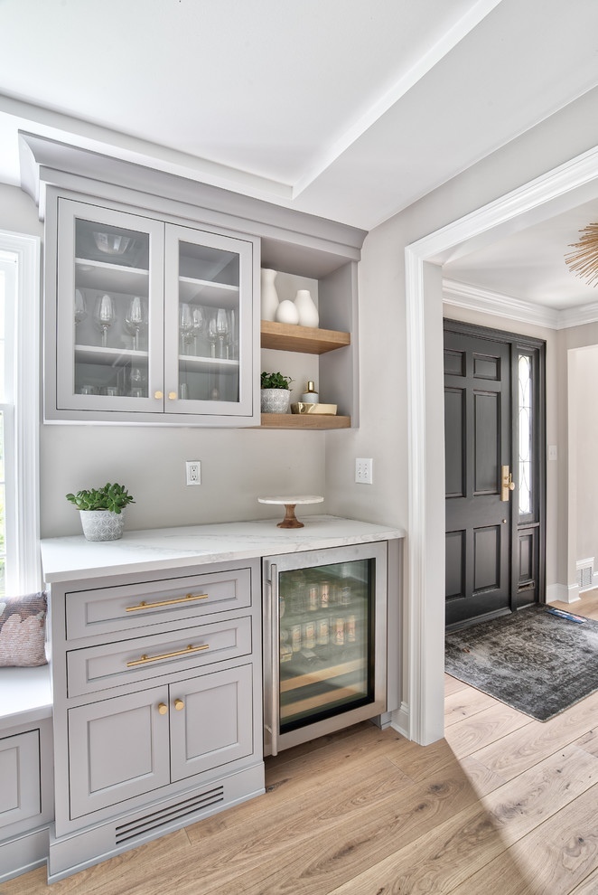 Inspiration for a large transitional kitchen in New York with an undermount sink, beaded inset cabinets, white cabinets, quartz benchtops, white splashback, mosaic tile splashback, panelled appliances, with island and white benchtop.