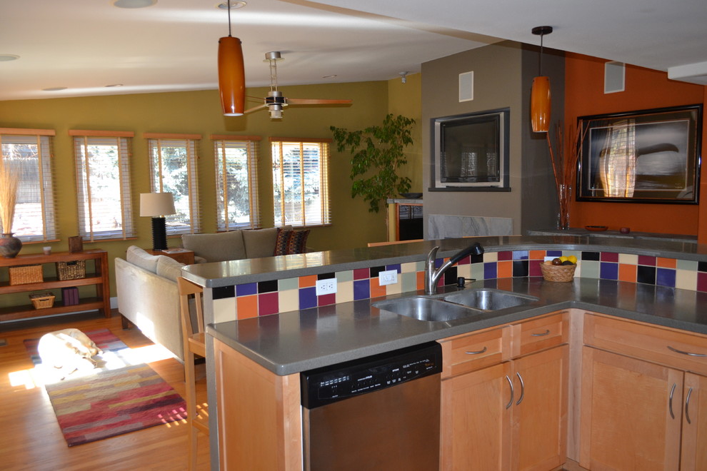 Open concept kitchen - small transitional l-shaped medium tone wood floor open concept kitchen idea in Denver with an undermount sink, shaker cabinets, light wood cabinets, solid surface countertops, multicolored backsplash, porcelain backsplash, stainless steel appliances and an island