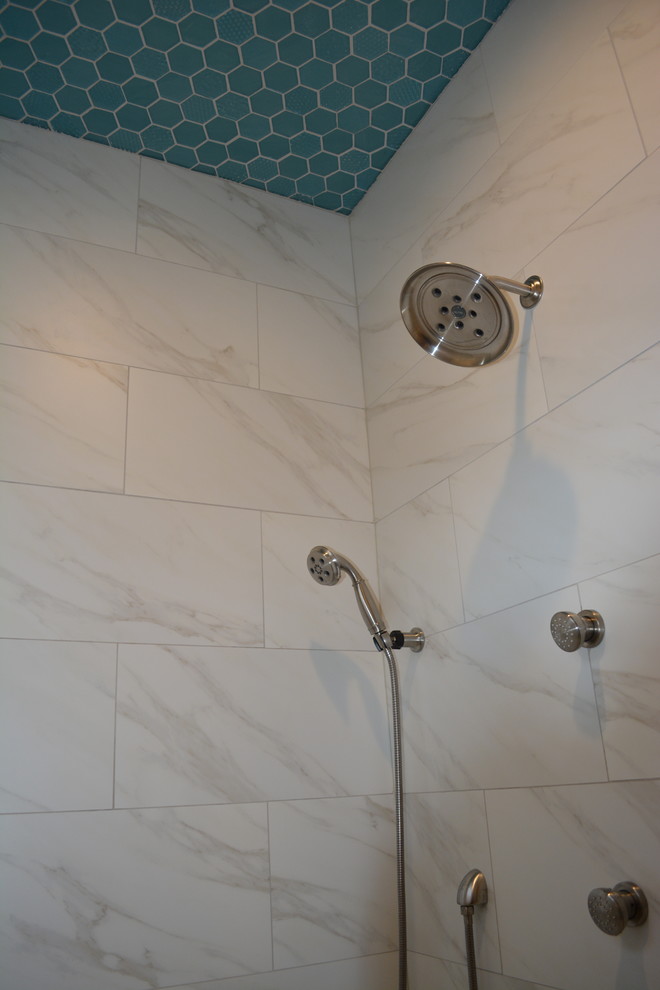 Alcove shower - mid-sized transitional master black and white tile and stone tile porcelain tile alcove shower idea with raised-panel cabinets, medium tone wood cabinets, beige walls, an integrated sink and solid surface countertops