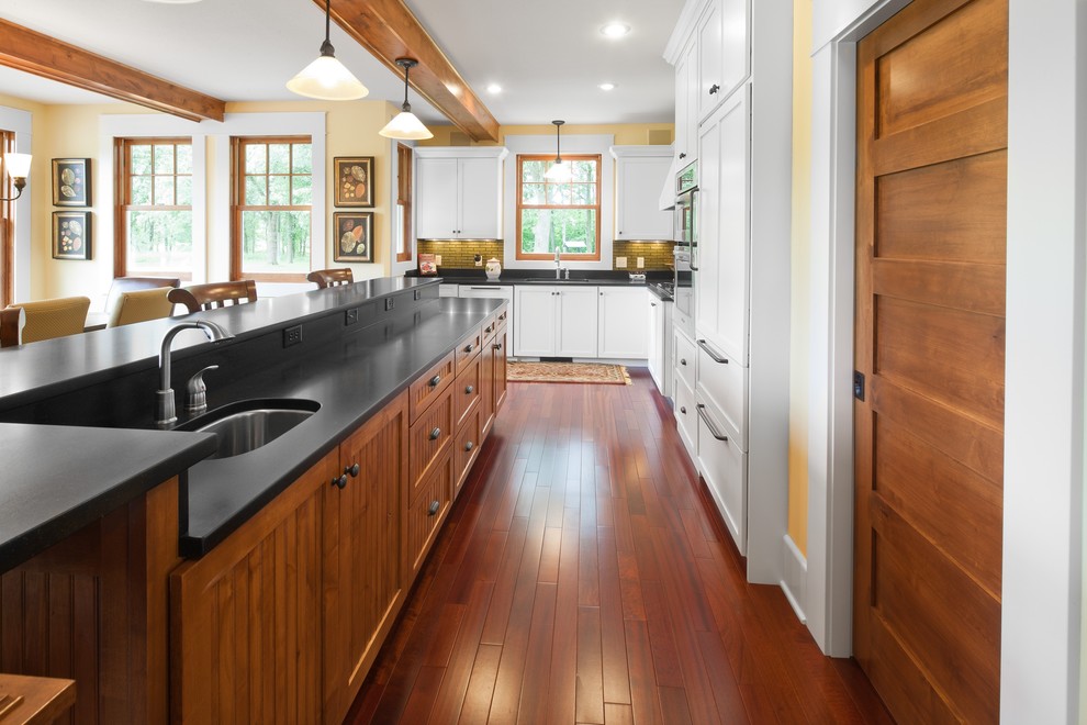 Traditional l-shaped eat-in kitchen in Minneapolis with an undermount sink, shaker cabinets, white cabinets, granite benchtops, panelled appliances and green splashback.