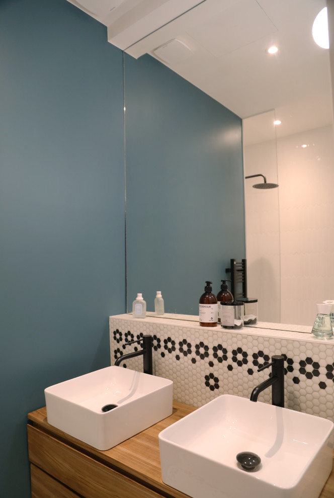 Exemple d'une petite salle de bain moderne pour enfant avec un bain bouillonnant, un carrelage blanc, mosaïque, un mur bleu, un sol en carrelage de terre cuite, un plan vasque, un plan de toilette en bois et meuble double vasque.