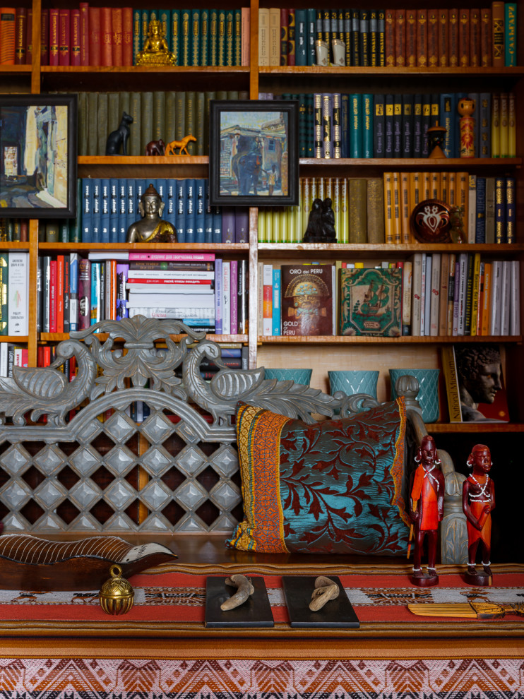 Cette image montre une petite salle de séjour bohème ouverte avec une bibliothèque ou un coin lecture, un mur beige, parquet foncé, aucune cheminée, aucun téléviseur, un sol marron et du papier peint.