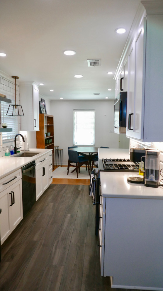 Inspiration for a mid-sized transitional galley porcelain tile and gray floor eat-in kitchen remodel with an undermount sink, shaker cabinets, white cabinets, quartz countertops, white backsplash, subway tile backsplash, black appliances, no island and white countertops