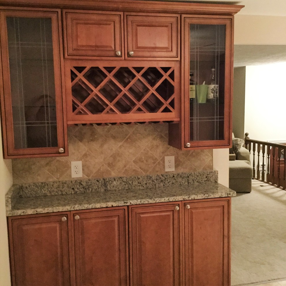 Inspiration for a large transitional l-shaped porcelain tile eat-in kitchen remodel in DC Metro with an undermount sink, raised-panel cabinets, medium tone wood cabinets, granite countertops, beige backsplash, porcelain backsplash, stainless steel appliances and an island