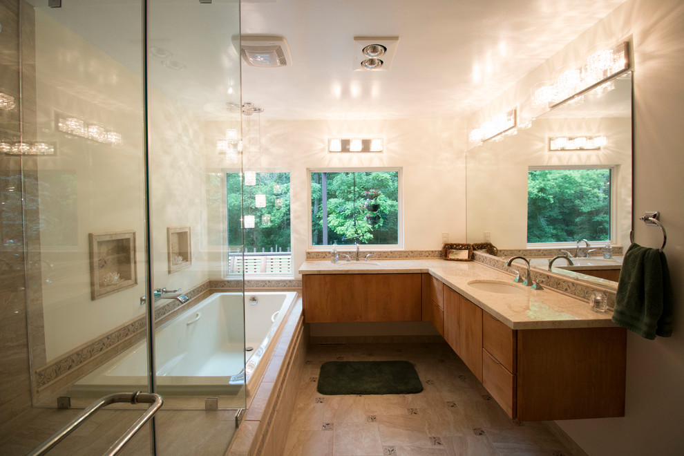 Inspiration for a mid-sized transitional master beige tile and ceramic tile ceramic tile drop-in bathtub remodel with an undermount sink, flat-panel cabinets, light wood cabinets, solid surface countertops, a two-piece toilet and beige walls