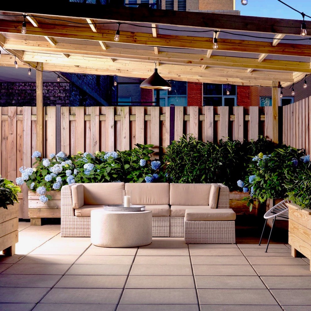 Inspiration for a small contemporary full sun rooftop concrete paver and wood fence landscaping in New York with a pergola for summer.