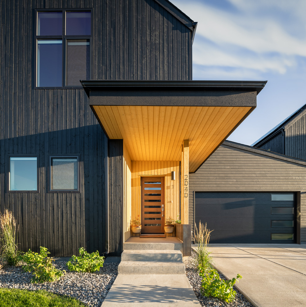 Стильный дизайн: двухэтажный, деревянный, черный многоквартирный дом в скандинавском стиле - последний тренд