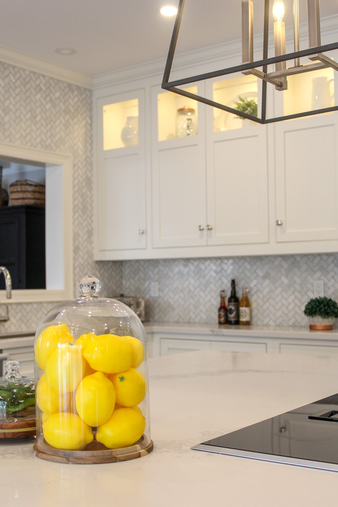 Example of a mid-sized transitional u-shaped dark wood floor and brown floor eat-in kitchen design in Toronto with an undermount sink, shaker cabinets, white cabinets, quartzite countertops, multicolored backsplash, mosaic tile backsplash, stainless steel appliances, an island and white countertops