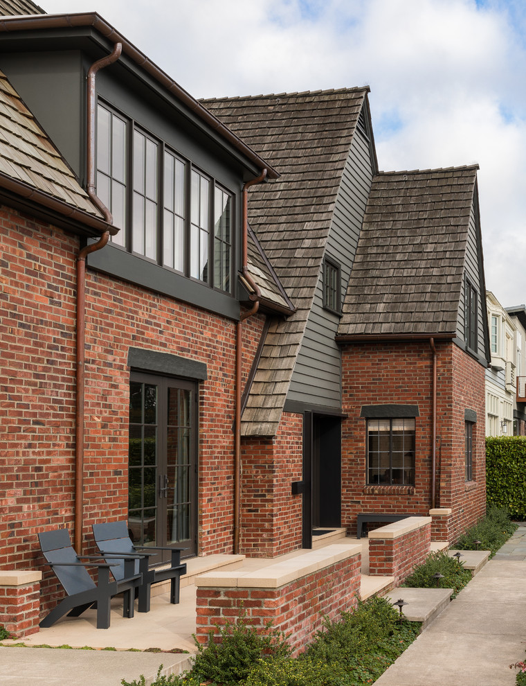 Inspiration for a large transitional concrete floor, beige floor and multicolored two-story brick gable roof remodel in Seattle with beige walls, a metal front door and a shingle roof