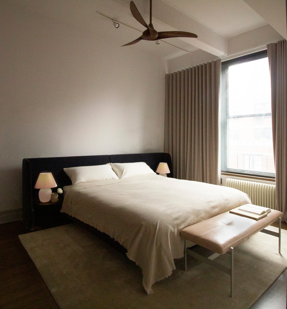 Foto de dormitorio tipo loft urbano de tamaño medio con paredes grises, suelo de madera en tonos medios, suelo marrón y vigas vistas