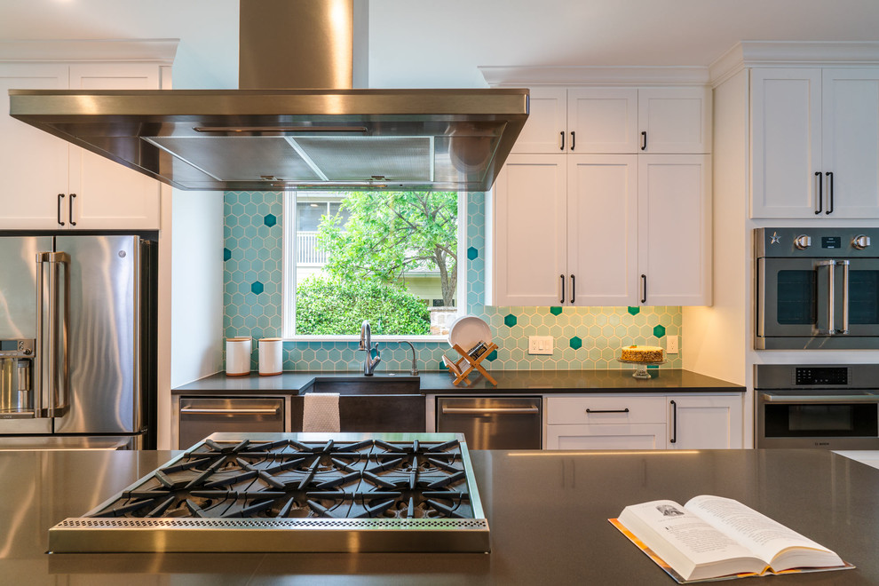 This is an example of a mid-sized contemporary kitchen in Austin with a farmhouse sink, shaker cabinets, white cabinets, quartzite benchtops, green splashback, ceramic splashback, stainless steel appliances, with island and black benchtop.