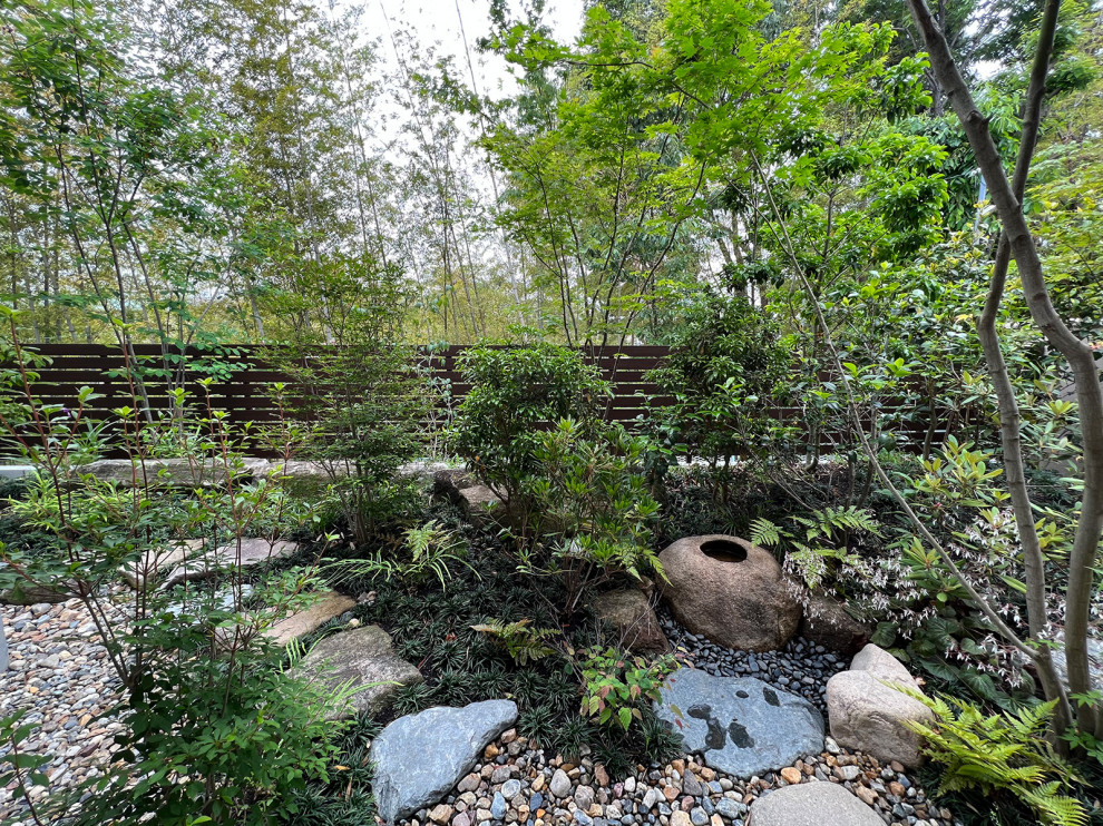 Immagine di un giardino minimalista esposto in pieno sole di medie dimensioni e in cortile in primavera con pavimentazioni in pietra naturale e recinzione in PVC