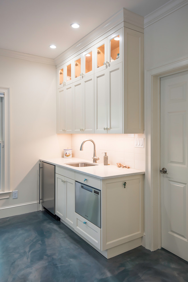 This is an example of a small beach style single-wall kitchen in Atlanta with an undermount sink, shaker cabinets, white cabinets, quartzite benchtops, white splashback, ceramic splashback, stainless steel appliances, concrete floors and blue floor.