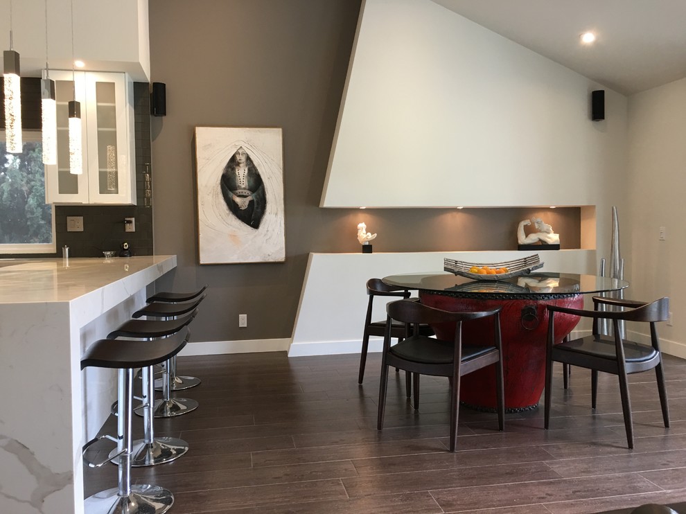 Photo of a mid-sized modern open plan dining in Orange County with multi-coloured walls, medium hardwood floors, no fireplace and grey floor.
